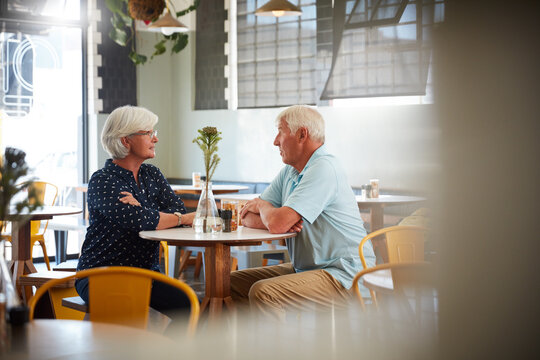 Relax, senior couple and talking in cafe for coffee break, bonding and support in retirement. Love, elderly people and conversation in restaurant for weekend date, healthy relationship and connection