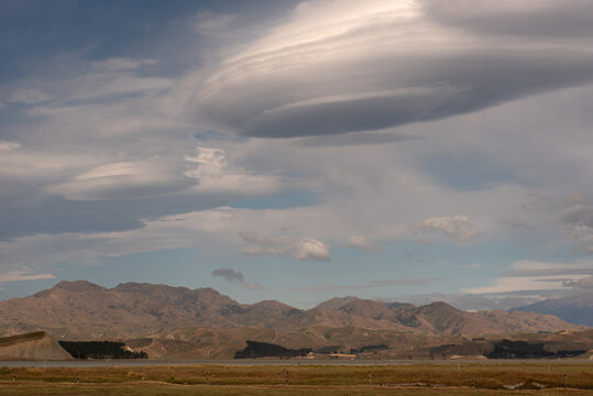 Lenticular clouds forming over the northern end of the Inland Kaikoura Range, viewed from Lake Grassmere, Marlborough, New Zealand.