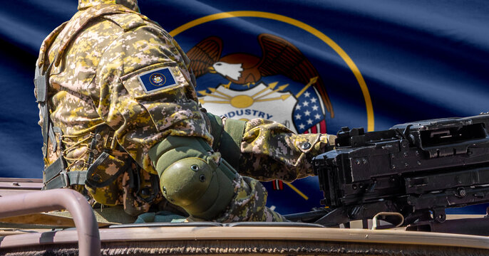 Utah US state flag with soldier at machine gun turret in front of it.