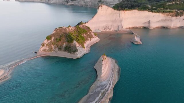Aerial drone orbit of the unique sea stacks and eroded white cliffs at Cape Drastis, Corfu, Greece. Close-up view of the layered rock formations in the Ionian Sea