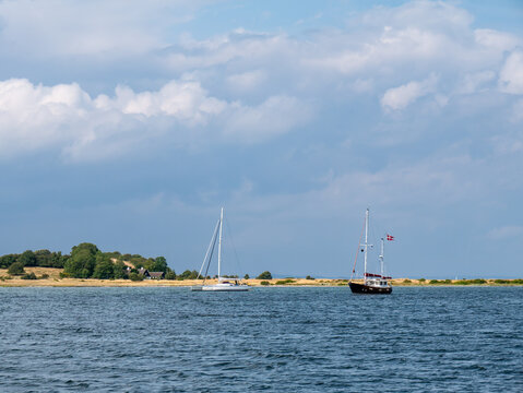 Sailboats anchored in sheltered bay near Lang&oslash;r with coastline of Sams&oslash; in background, Denmark