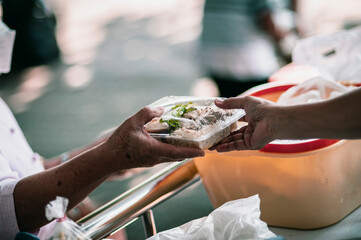 The hands of the hungry get food from the hands of volunteers, Food Donations for Homeless
