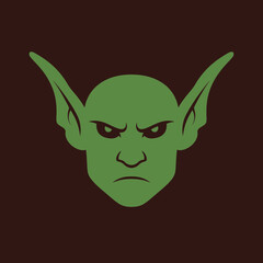 Illustration of a green goblin face with pointed ears and an angry expression.