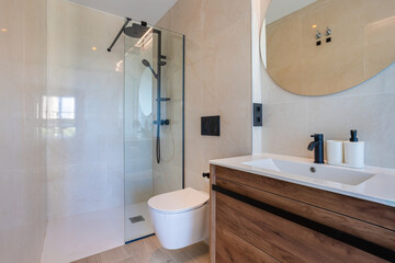 Modern minimalist bathroom with glass shower, wood vanity, and matte black fixtures
