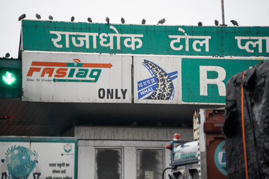 Fastag and NHAI national highway authority of India on top of toll booth showing the enforcement fo digital payment only across the country