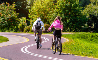 Fototapeta premium Cyclists ride on the bike path in the city Park 