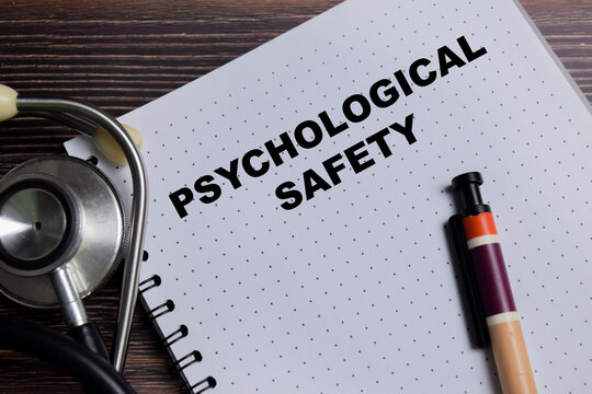 Concept of psychological safety write on book isolated on Wooden Table. For trust and open communication