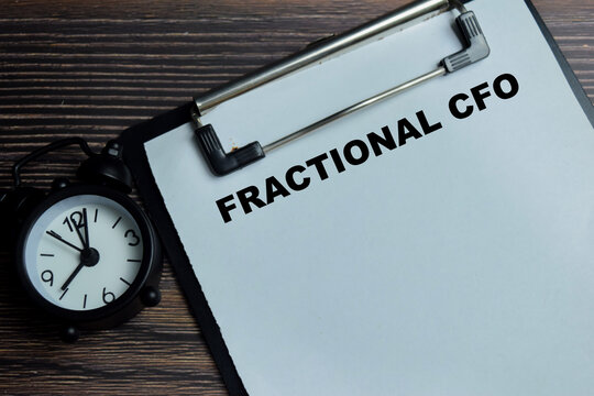 Concept of fractional CFO write on clipboard isolated on Wooden Table. For startup small business and strategic finance management