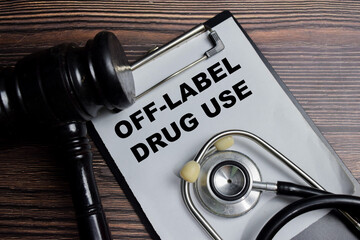 Concept of off-label drug use write on clipboard isolated on Wooden Table. Legal risk communication...