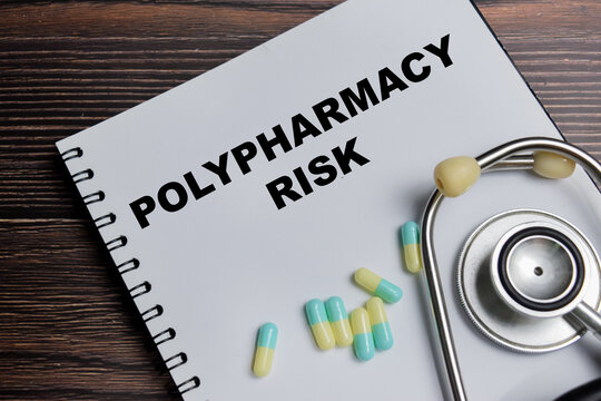 Concept of polypharmacy risk write on book isolated on Wooden Table. For multiple medication use and drug interaction