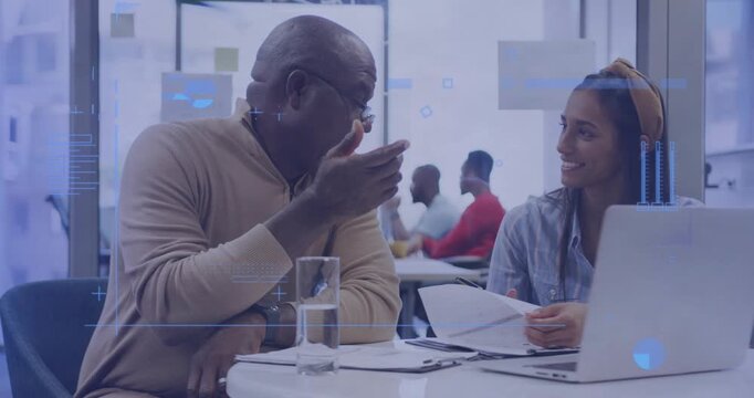 Senior mentor reviewing business charts, guiding mentee through data while annotating laptop screen