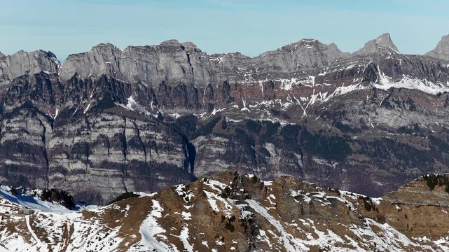 Rocky alpine peaks with light snow above Walensee viewed from Flumserberg
