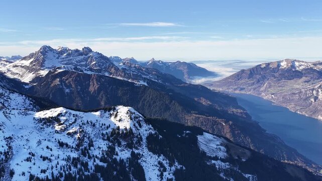 Alpine mountains and Walensee lake viewed from high snowy ridge