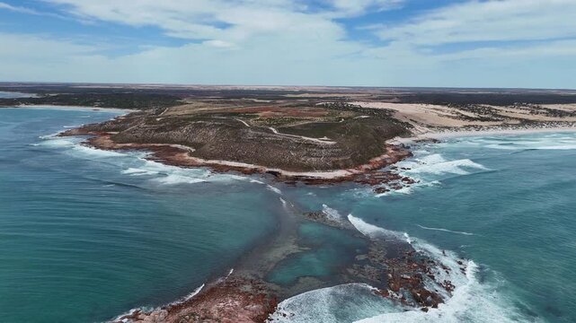 Aerial establishing of rugged headland and swirling ocean waves at Salmon Hole near Daly Head, dolly with whitewash water