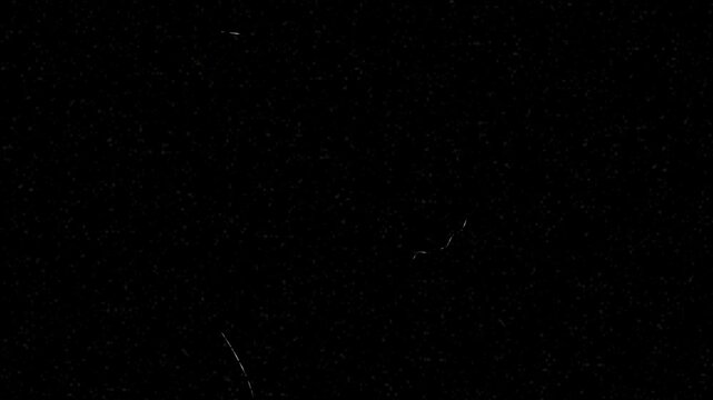 Fine film grain and thin scratches drift subtly across a deep black screen. Adds cinematic wear and analog texture subtly. Ideal for film overlays and motion design.