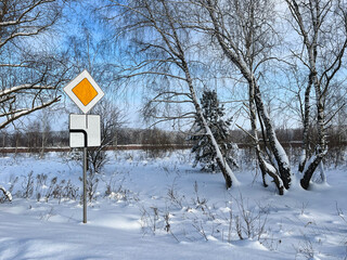 Road sign "main road" in rural areas. Winter.