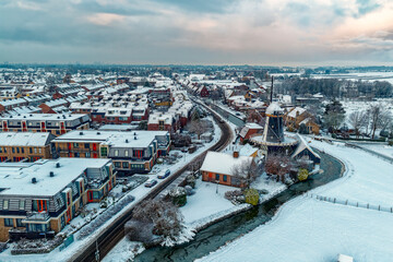 Obraz premium Aerial view of Benthuizen village with traditional Dutch windmill in winter