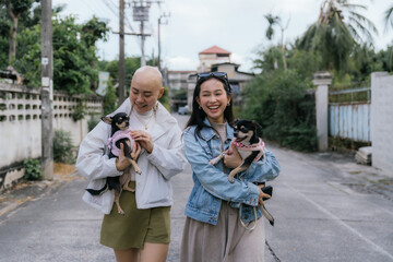 Cheerful women walking dogs on a street