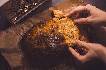 Female hands holding a piece of delicious cake on parchment