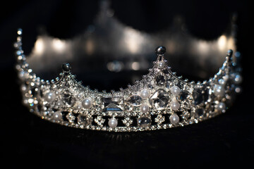 Obraz premium White golden crown with crystals, diamonds on black background.