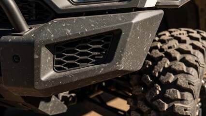 Close-up of a rugged off-road vehicle's front bumper and tire.