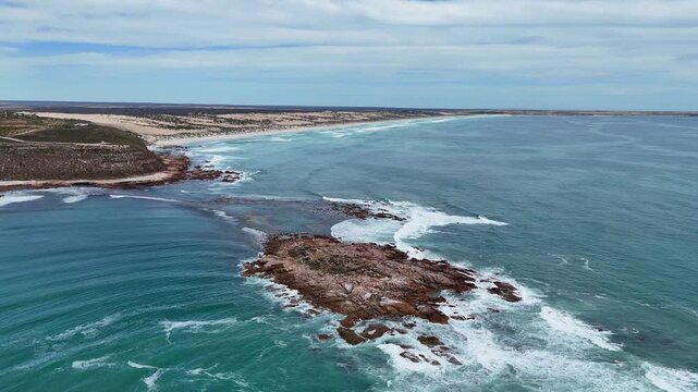 Aerial establishing of dramatic coastal headland and surrounding ocean at Salmon Hole, Daly Head, orbit tracking over current waves crashing with whitewash