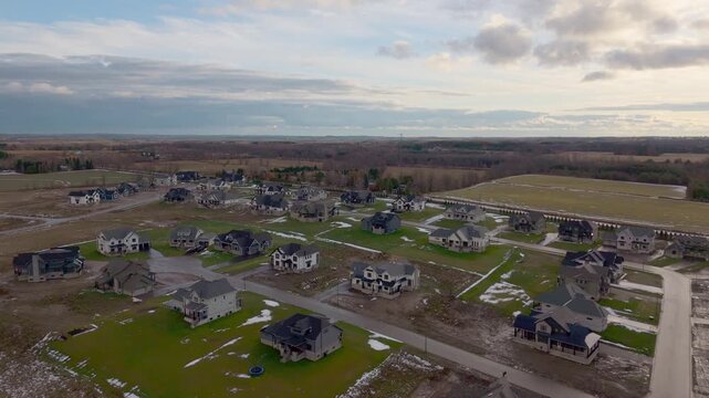 Aerial establishing of Alton large green new development housing lot area during early snowfall, a quiet winter and mud melt landscape