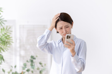 悩む女性　スマートフォン
