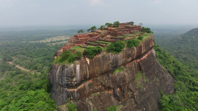 Sri Lanka aerial view of Sigiriya monolith with nearby wetlands and forest, showing the fortress summit and surrounding green expanse.