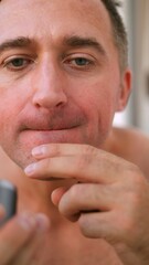 Naklejka premium Vertical photo Individual carefully examines teeth alignment and lip structure in mirror, Person meticulously assesses oral features and smile characteristics before capturing images, Thorough facial