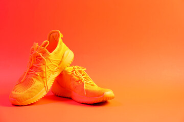 Pair of stylish sneakers on orange background. Space for text