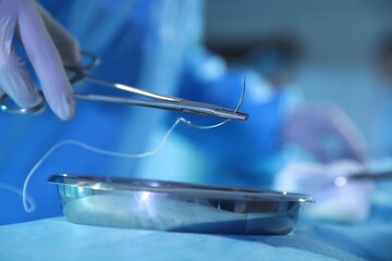Professional surgeon with medical tools performing operation in surgery room, closeup