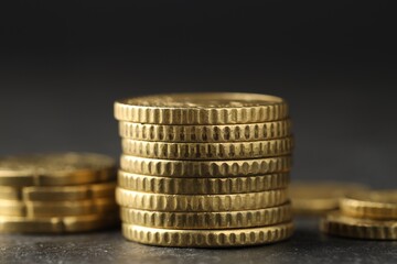 Many stacked coins on table against blurred background, closeup