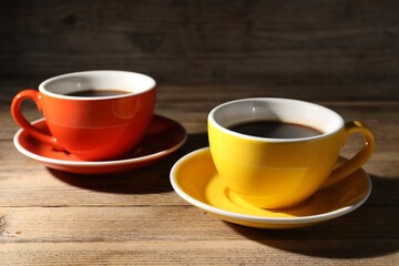 Obraz premium Cups of aromatic coffee on wooden table, closeup