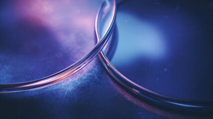 Abstract metallic rings in blue and purple light with textured background.