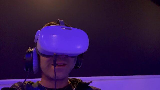 Close-up of man wearing a virtual reality headset and headphones, experiencing an immersive 3D environment with dramatic lighting, representing modern technology, innovation, and digital entertainment