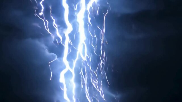 Multiple electric thunder bolts striking through dark cloudy night sky for dramatic severe weather loop.