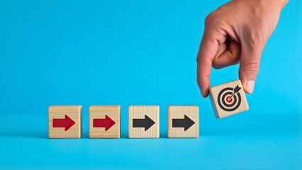 Hand placing target block amidst arrow blocks, symbolizing strategic goal setting, focused direction, and the path to achieving business success