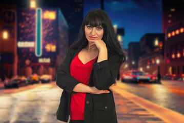 A woman in a purple jacket is standing on a city street