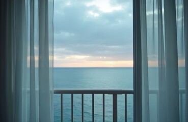 Obraz premium View of ocean sunset through sheer curtains from hotel room balcony. Calm water and sky with soft clouds. Peaceful atmosphere for vacation or relaxation.