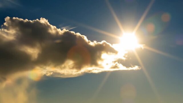 Stunning sunburst breaking through dramatic clouds in bright blue sky