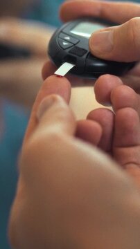 Person carefully uses glucose meter to monitor blood sugar levels in health monitoring session, either at home or in a clinic, a crucial step for effective diabetes management and overall health check