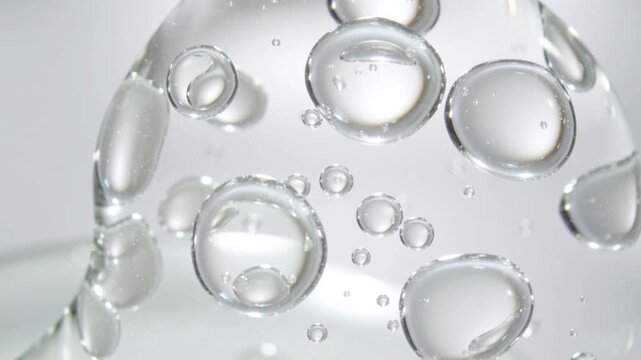 Realistic cosmetic serum bubbles float smoothly in liquid, macro texture of scientific product for deep hydration and facial skin rejuvenation.