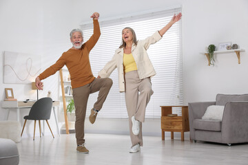 Fototapeta premium Happy senior couple dancing together at home