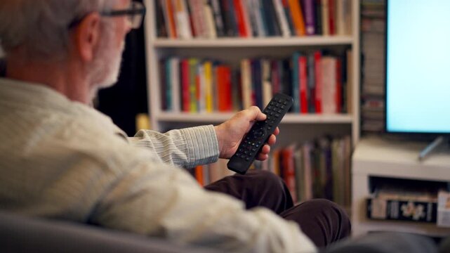 Elderly man watching television alone at home.