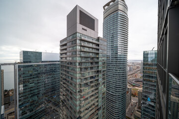 Naklejka premium Toronto financial district and waterfront featuring contemporary high rise skyscrapers, residential buildings, and a busy urban landscape under an overcast sky. In mimco