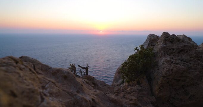 Sonnenaufgang &uuml;ber ruhiger Meeresfl&auml;che mit klarer Horizontlinie, erste Sonnenstrahlen steigen langsam aus dem Wasser auf, sanfte Farbverl&auml;ufe am Himmel und stille Morgenstimmung &uuml;ber dem Meer