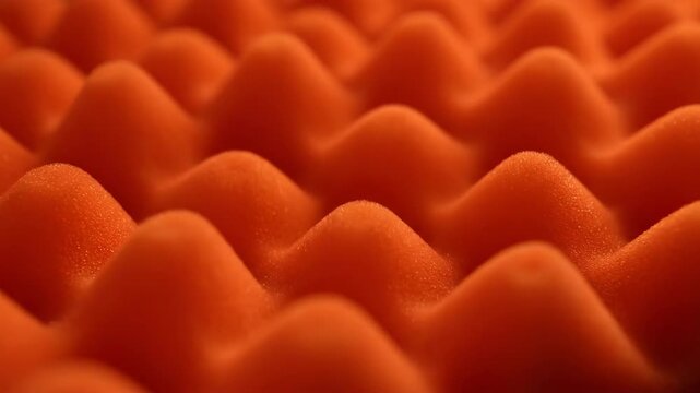 Close-up of orange soundproof foam with acoustic dampening for studio with geometric texture.