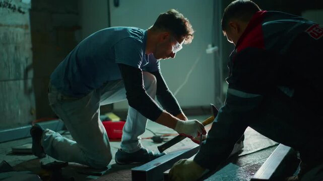 apprentice installs tiles, trainer guides apprentice during tile setting, closeup view of apprentice tapping tiles while instructor provides guidance during installation