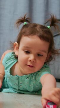 young child pushes vehicle during playful exploration, toddler girl concentrates intensely on toy car race